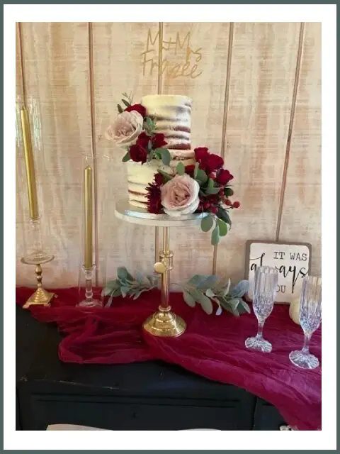 A cake on top of a stand with flowers.